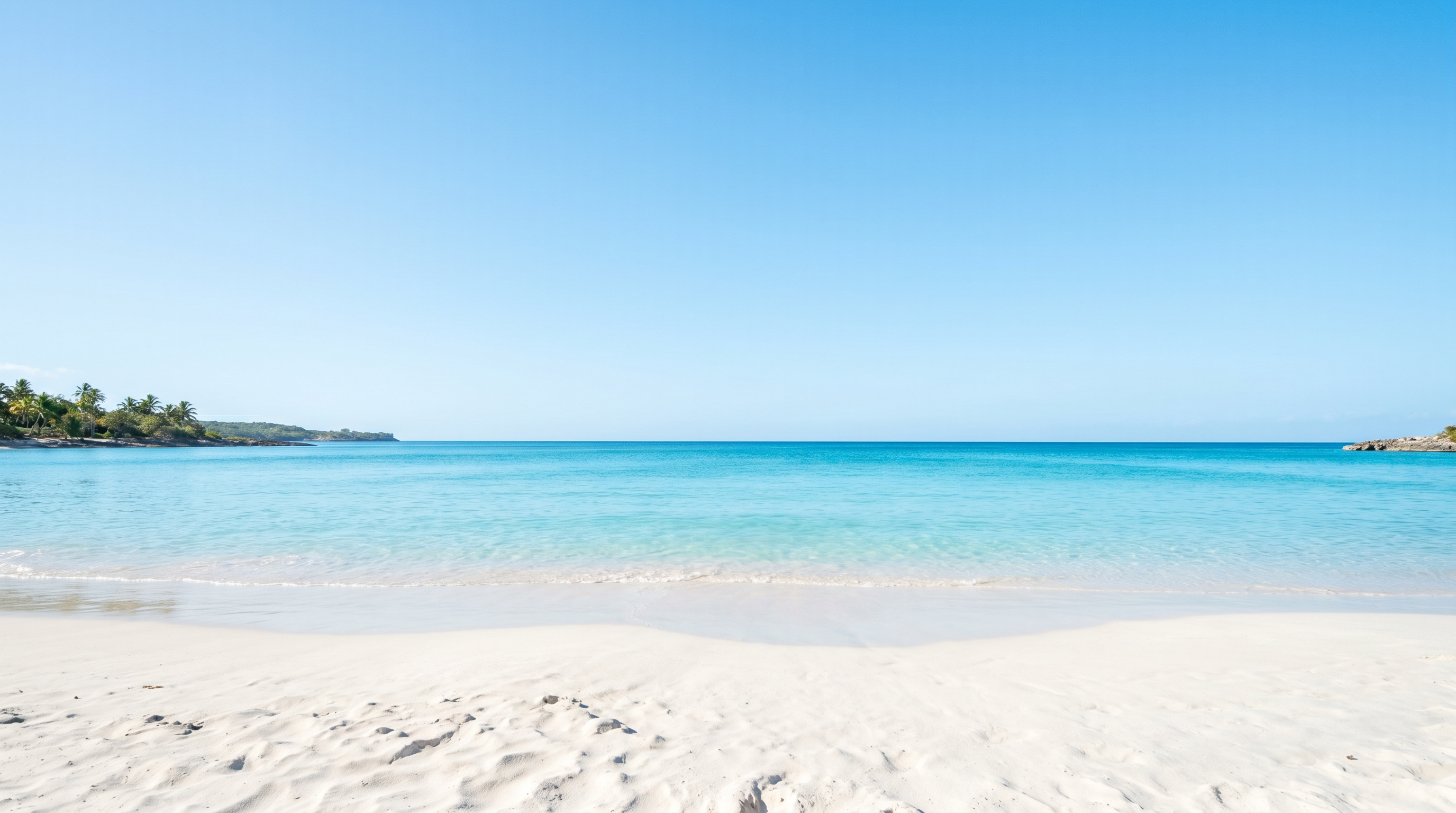 Bright turquoise beach with clear blue sky and white sand